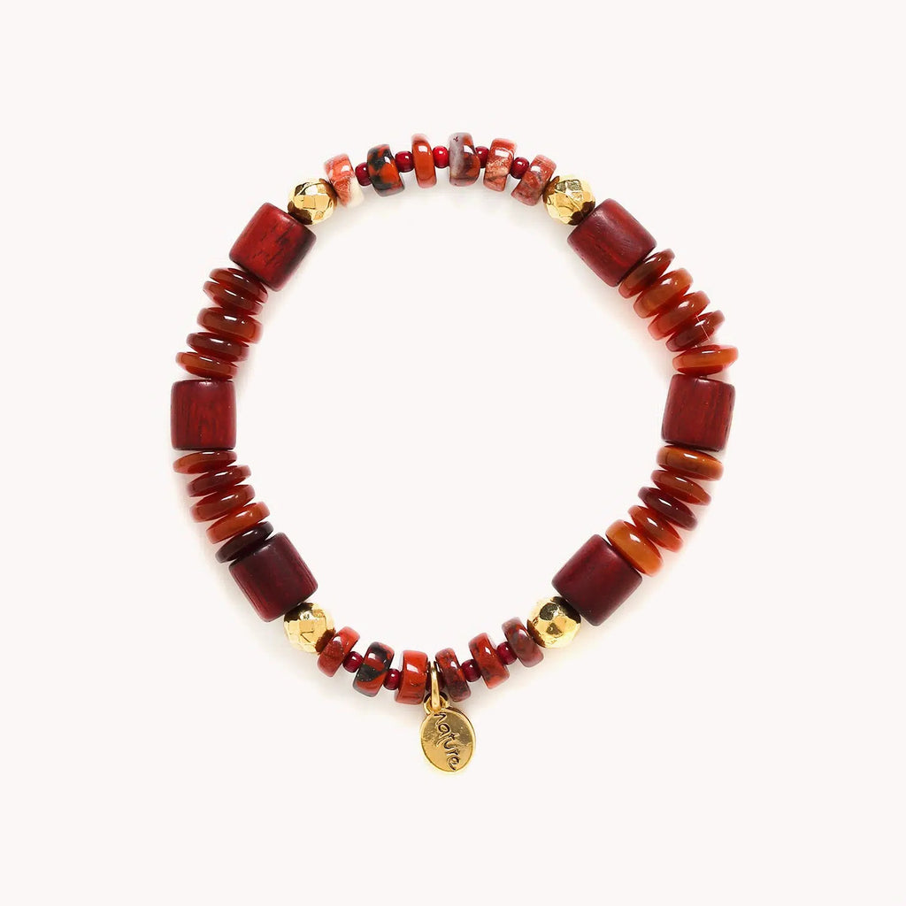 Bracelet composé de perles longues en bois de rose, de perles plates et de petites perles rondes en pierre naturelle à dominante rouge orangé agrémenté de perles rondes facettées dorées à l'or fin. 
