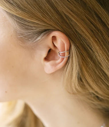 Oreille d'une femme agrémentée d'un earcuff (manchette d'oreille) Randa en acier 